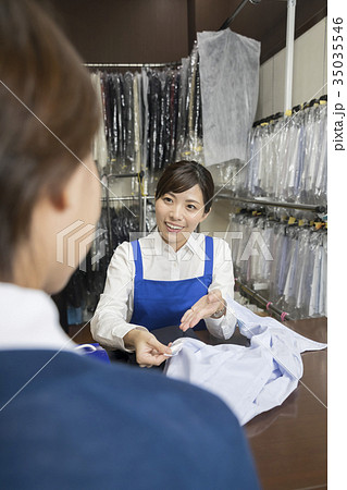 クリーニング店にクリーニングをお願いする女性 クリーニング店にクリーニングをお願いする女性 35035546