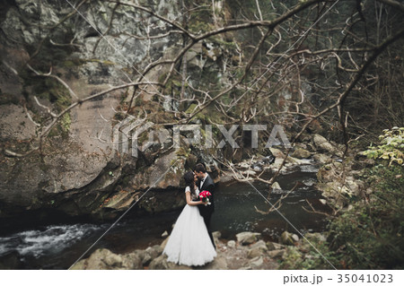Wedding couple in love kissing and hugging near Wedding couple in love kissing and hugging near 35041023