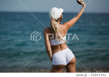 Beautiful blonde girl in sportwear on the beach 35041502