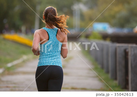 Young woman runner jogging in park in the morning Young woman runner jogging in park in the morning 35042613