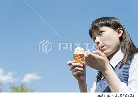 女子高生 アイスクリーム 青空の写真素材