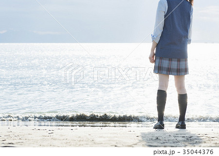 女子高生 海 後ろ姿 輝きの写真素材