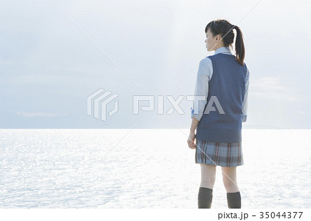 女子高生 海 後ろ姿 輝きの写真素材
