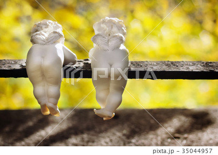 Funny ceramic angels are back view in autumn park. 35044957