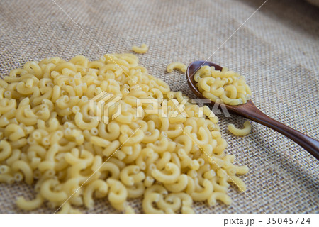 Macaroni Raw pasta in wooden spoon on sack rustic 35045724