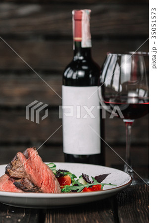 Grilled beefsteak with glass of red wine  35051573