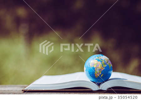 本の上に置かれた地球儀と緑ボケ背景 35054520