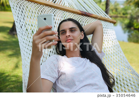 Relaxed young woman looking at mobile phone 35054646