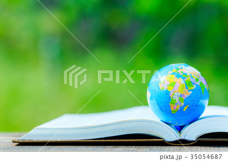 本の上に置かれた地球儀と緑ボケ背景 35054687