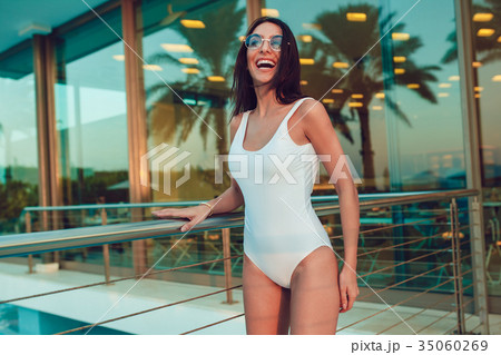 Sexy woman in white swimsuit posing outdoors. Mock 35060269