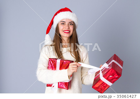 Woman in red christmas hat holding presents 35061427