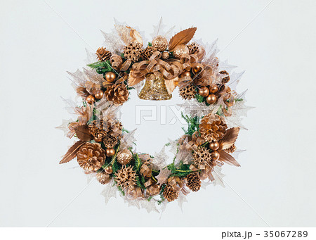 金色のぼっくりと造花のクリスマスリースの写真素材