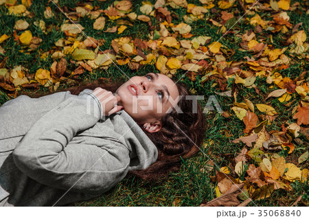 Fall portrait of a girl lying on a lawn in a Fall portrait of a girl lying on a lawn in a 35068840
