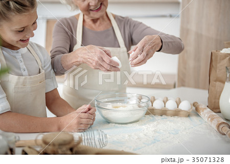 Happy grandmother teaching girl to make dough Happy grandmother teaching girl to make dough 35071328