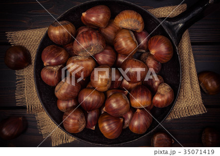 chestnuts in a pan on a wooden background chestnuts in a pan on a wooden background 35071419