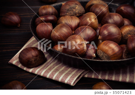 chestnuts in a pan on a wooden background chestnuts in a pan on a wooden background 35071423