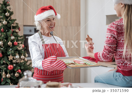 Kind senior woman treating granddaughter by 35071590