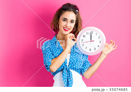 Woman holding clock showing nearly 12 Woman holding clock showing nearly 12 35074685