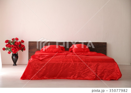 the Interior of the white room with a bed with red 35077982