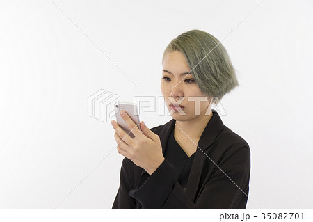 人物　女性　20代　白背景 スマホ　バストショット　見る　無表情 35082701