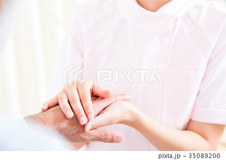 若い看護師とおじいちゃん 手を握る 手に触れる 老人ホーム デイケアセンター 車椅子 の写真素材 3500