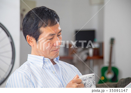 読書をする中年男性　ミドル世代　中高年　短髪の男性　カジュアル　普段着　男の人 35091147