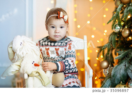 Cute little girl holding toy santa and snowman 35096897