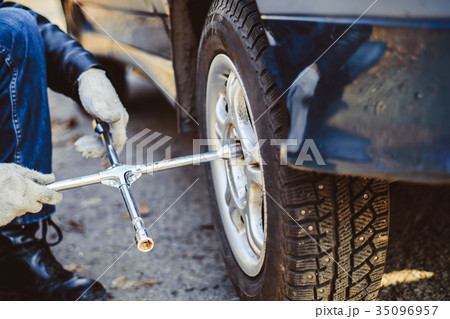 man changing wheel on a car man changing wheel on a car 35096957