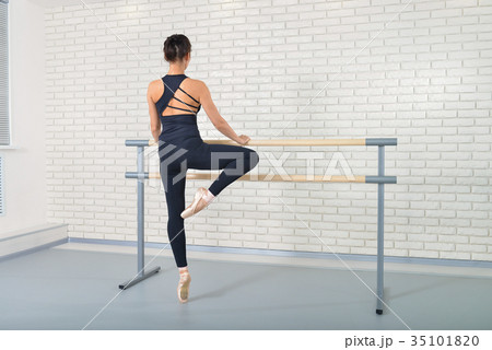 Ballerina stretches herself near barre at ballet Ballerina stretches herself near barre at ballet 35101820
