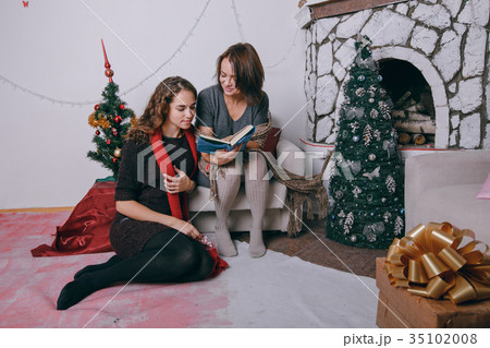 Mom and daughter decorating Christmas tree 35102008