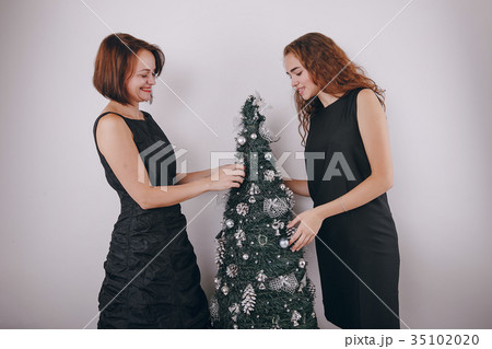 Mom and daughter decorating Christmas tree Mom and daughter decorating Christmas tree 35102020
