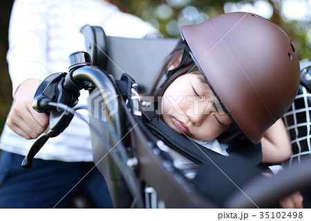 自転車 子供 送迎 送り 迎え 二人乗り電動アシスト自転車 二人乗り ママ 母親 熟睡 寝る の写真素材