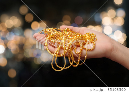 woman hand hold gold bracelet and necklace jewelry woman hand hold gold bracelet and necklace jewelry 35103590