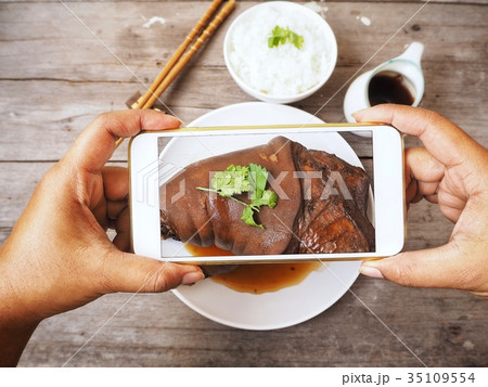 Taking a photo of braised pork with smart phone 35109554