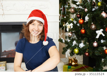 Young girl sitting xmas tree 35113524