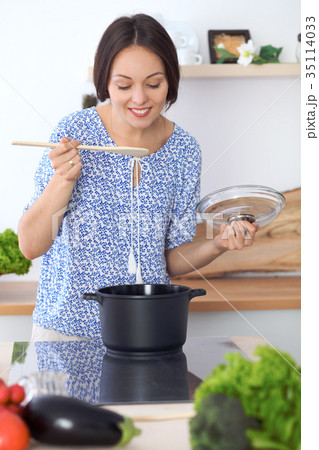 Woman cooking soup in kitchen. Healthy meal and 35114033