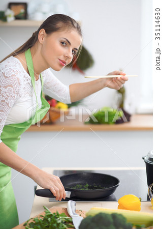 Young woman housewife cooking in the kitchen 35114630