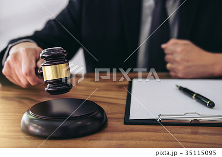 Male lawyer or judge hand's striking the gavel on sounding block 35115095