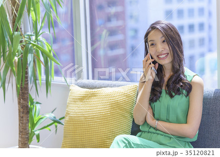 日差しが心地良い窓際のソファに座りスマホを操作でミスってしまったロンミスグヘアーの綺麗な美人女性 35120821