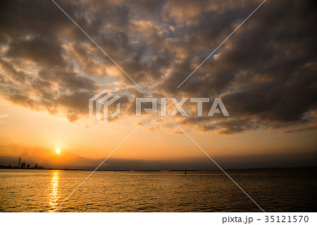 夕日 夕方 夕焼け 海 シルエット 海岸線 逆光 海岸線の写真素材