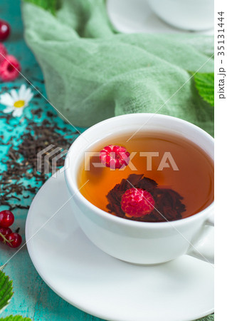 White cup of tea with raspberries closeup White cup of tea with raspberries closeup 35131444
