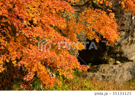 北海道厚沢部町のホイド穴跡と呼ばれる洞穴とその近くの紅葉を撮影の写真素材