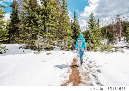 Tourist with backpack hiking on snowy trail 35134643