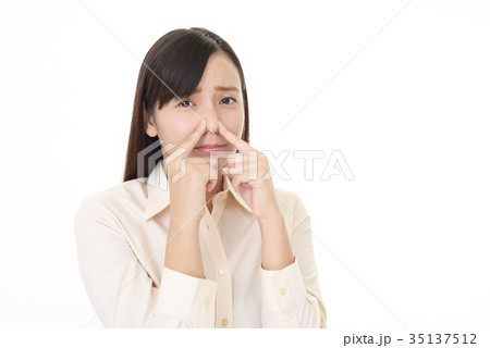 鼻をつまむ女性の写真素材