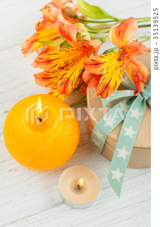 Arrangement of orange lily flowers and candle 35139525
