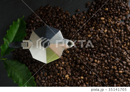 Italian coffee maker and coffee beans with leaves Italian coffee maker and coffee beans with leaves 35141705