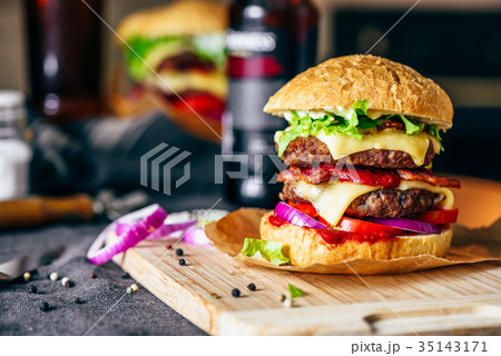 Cheeseburger on Cutting Board with Bottle of Beer Cheeseburger on Cutting Board with Bottle of Beer 35143171
