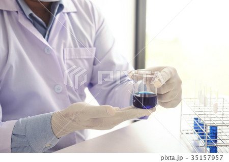 Scientist or medical in lab coat holding test tube with reagent, Scientist or medical in lab coat holding test tube with reagent, 35157957