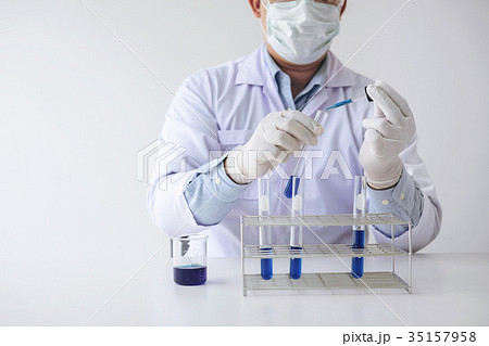 Scientist or medical in lab coat holding test tube with reagent Scientist or medical in lab coat holding test tube with reagent 35157958