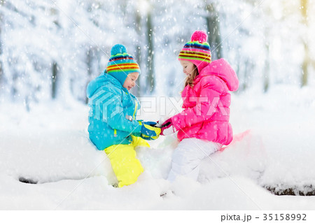 Kids playing in snow. Children play in snowfall. 35158992